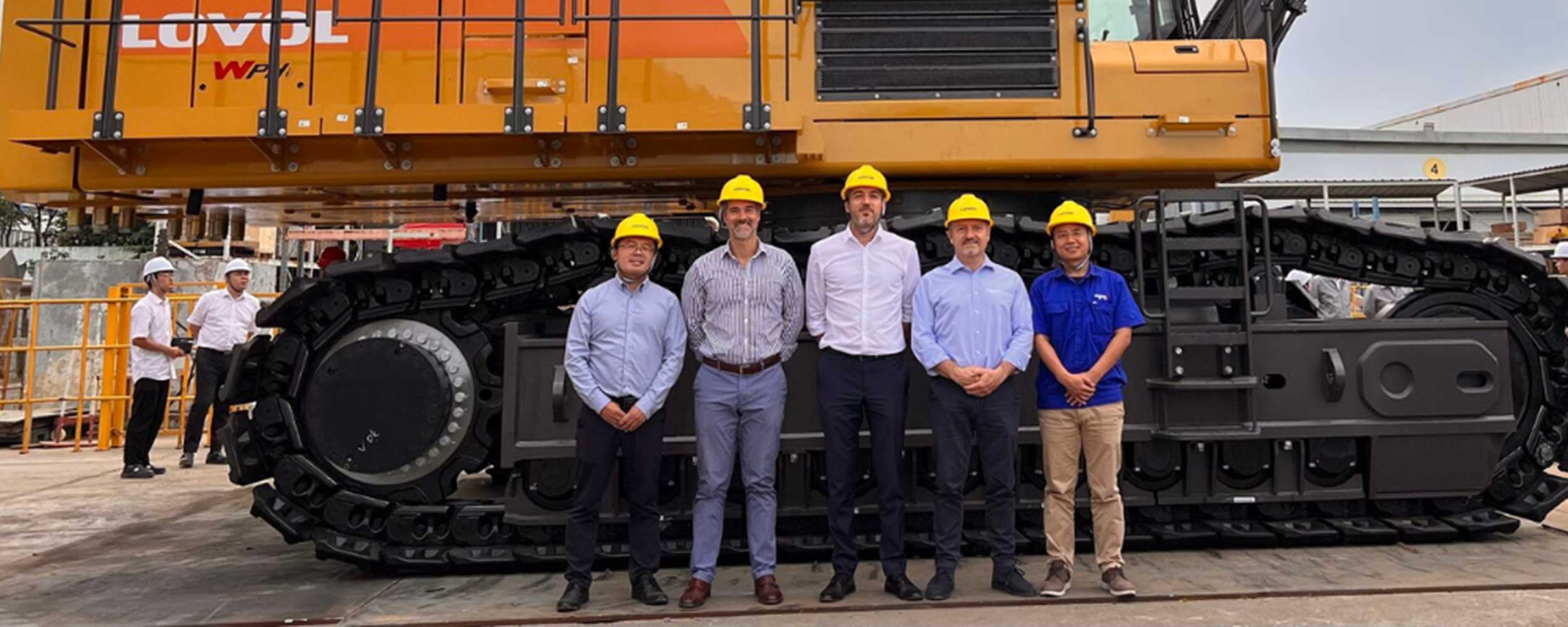 Five men stood in front of a yellow Lovol excavator.